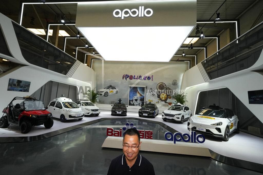 Ng Han Guan Wei Dong, vice president of Baidu's Intelligent Driving Group, speaks near a display showing the various prototypes of the self-driving taxi developed by tech giant Baidu Inc. on June 14, 2022, in Beijing. Baidu Inc. is China's highest-profile competitor in a multibillion-dollar race with Alphabet Inc.'s Waymo and General Motors Co.'s Cruise to create self-driving cars. (AP Photo/Ng Han Guan)