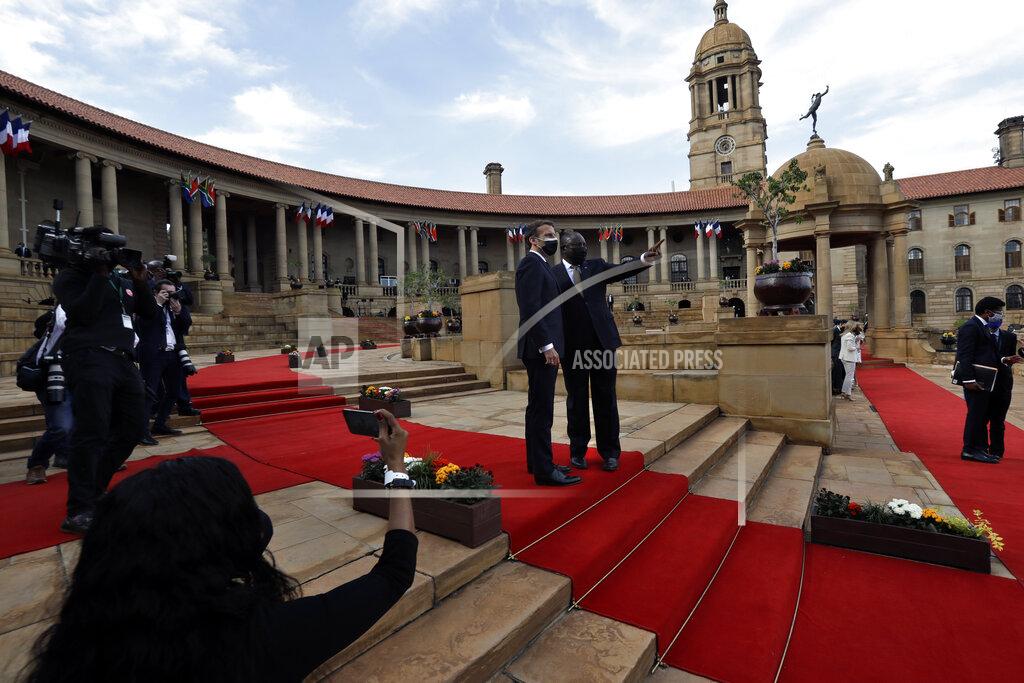 Themba Hadebe South African President Cyril Ramaphosa, center right, and his French counterpart Emmanuel Macron talk during a welcoming ceremony at the government's Union Buildings, in Pretoria, South Africa, Friday, May 28, 2021. Macron is on a two-day official visit to the country. (AP Photo/Themba Hadebe, Pool)