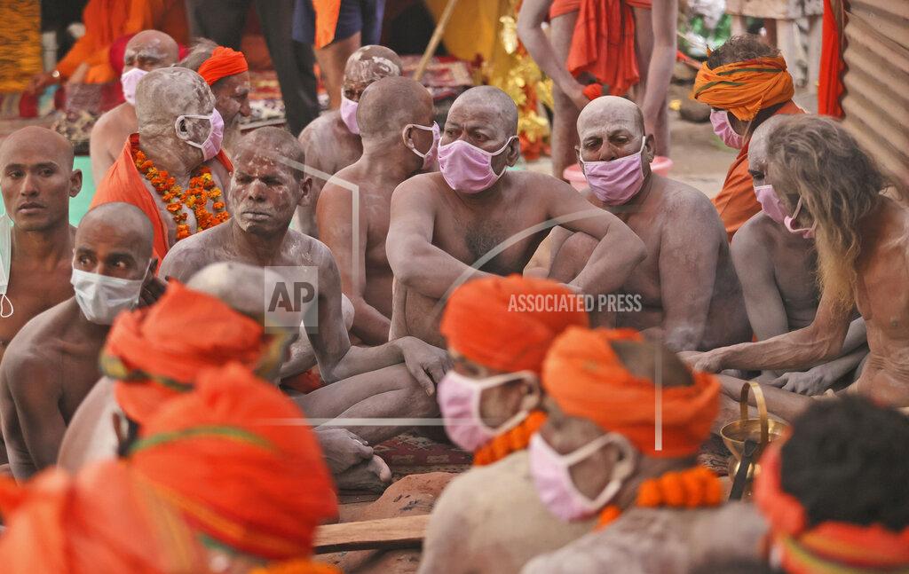 Karma Sonam Naga Sadhu or Naked Hindu holy men wait for the start of a procession towards the river Ganges for Shahi snan or a Royal bath during Kumbh mela, in Haridwar in the Indian state of Uttarakhand, Monday, April 12, 2021. As states across India are declaring some version of a lockdown to battle rising Covid cases as part of a nationwide second-wave, thousands of pilgrims are gathering on the banks of the river Ganga for the Hindu festival Kumbh Mela. The faithful believe that a dip in the waters of the Ganga will absolve them of their sins and deliver them from the cycle of birth and death. (AP Photo/Karma Sonam)
