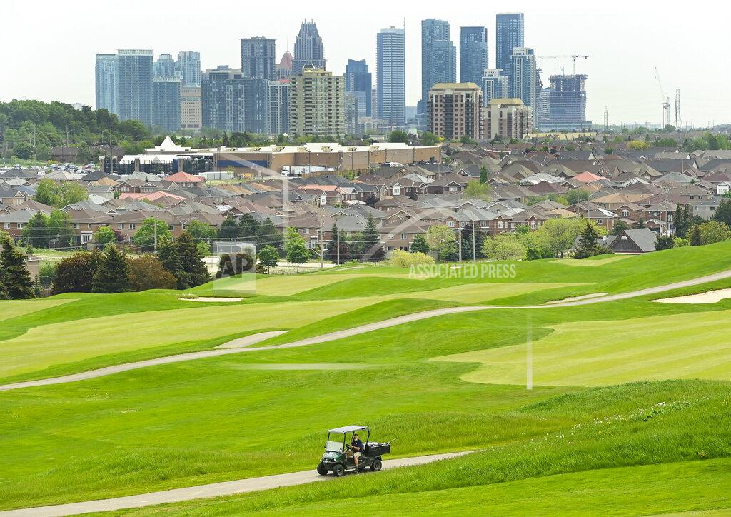Nathan Denette A maintenance worker prepares the final finishing touches at BraeBen Golf Course as all golf courses are set to open Saturday in Mississauga, Ontario, Friday, May 21, 2021. (Nathan Denette/The Canadian Press via AP)