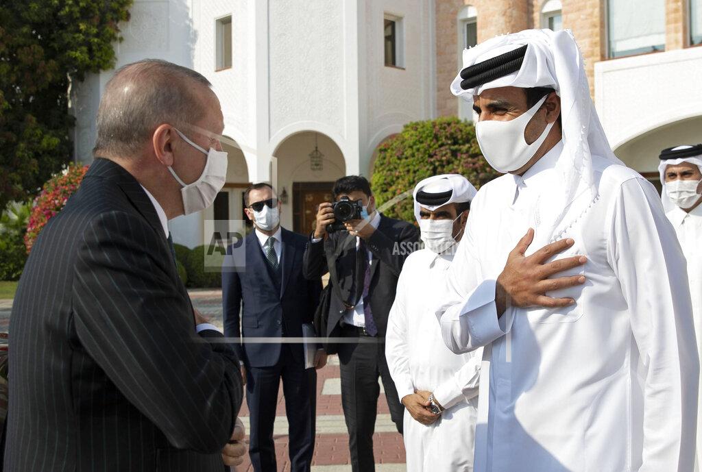 Uncredited In this photo released by the Qatar Amiri Diwan, Turkish President Recep Tayyip Erdogan, left, is welcomed by Emir of Qatar Sheikh Tamim bin Hamad Al Thani, after his arrival in Doha, Qatar, Wednesday, Oct. 7, 2020. (Qatar Amiri Diwan via AP)