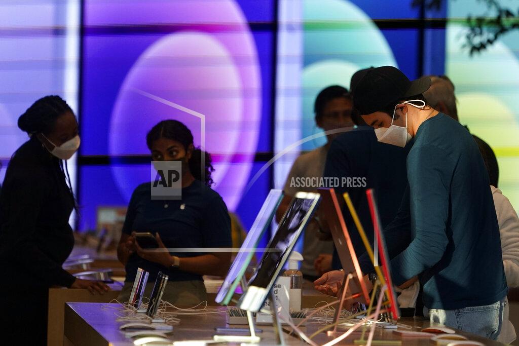 Marcio Jose Sanchez FILE - In this June 9, 2021, file photo, workers and customers wear masks inside an Apple Store amid the COVID-19 pandemic on The Promenade, in Santa Monica, Calif. California regulators on Thursday, June 17, 2021, are set to approve revised worksite pandemic rules that allow fully vaccinated employees the same freedoms as when they are off the job. (AP Photo/Marcio Jose Sanchez, File)