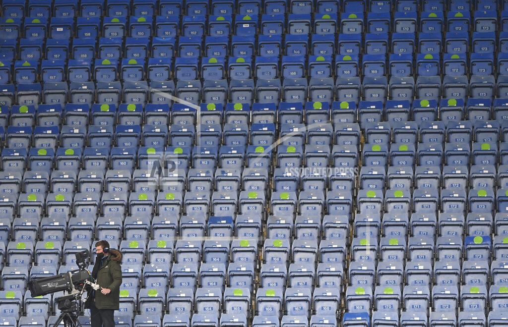 A TV cameraman wears a face mask sets up his camera before the start of the English Premier League soccer match between Chelsea and Fulham at Stamford Bridge Stadium in London, Saturday, May 1, 2021. (Justin Setterfield/Pool via AP)