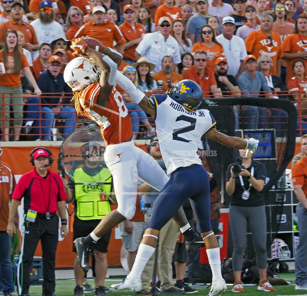 Michael Thomas Texas receiver Lll'Jordan Humphrey, left, catches a pass against West Virginia defender Kenny Robinson, Jr. during the second half of an NCAA college football game, Saturday, Nov. 3, 2018, in Austin, Texas. West Virginia won 42-41. (AP Photo/Michael Thomas)