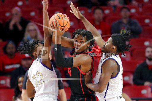 Houston center Josh Carlton, center, looks to pass the ball from between Alcorn State guards Dekedran Thorn (12) and Darius Agnew, right, during the first half of an NCAA college basketball game Monday, Dec. 6, 2021, in Houston. (AP Photo/Michael Wyke)