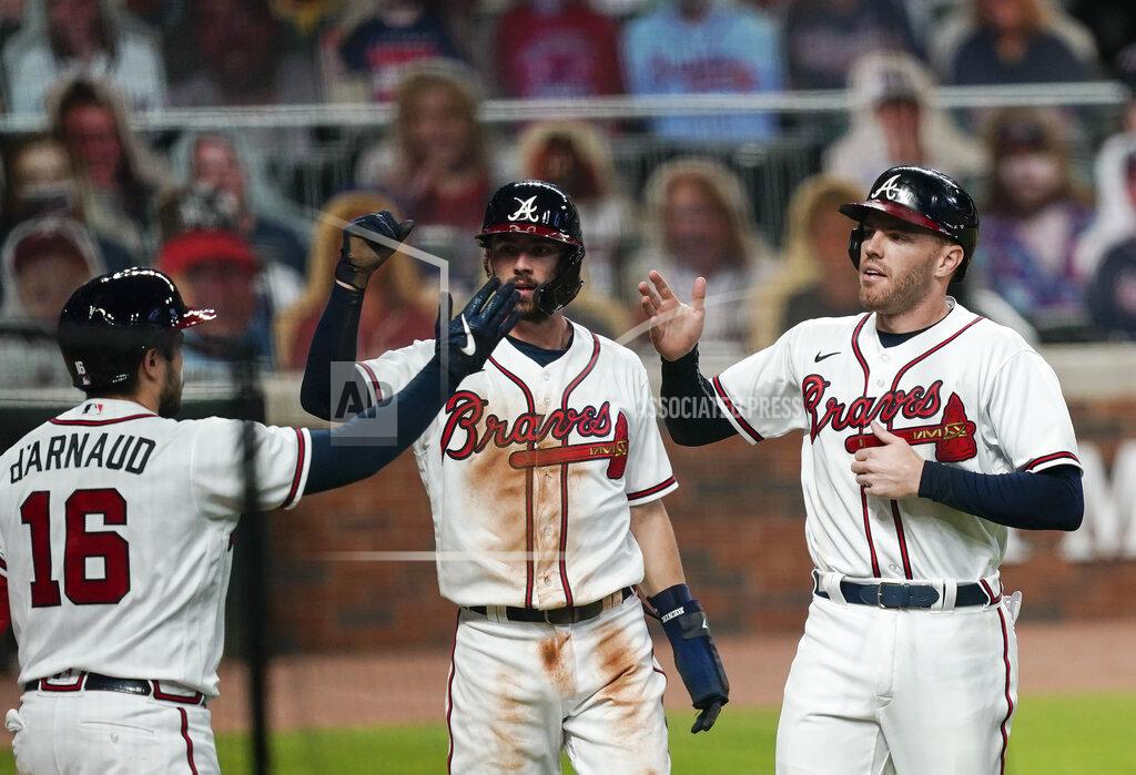 Brynn Anderson Atlanta Braves' Dansby Swanson, center, and Adam Duvall, right, celebrate with Travis d'Arnaud, left, after scoring on a double hit by teammate Marcell Ozuna in the fifth inning of a baseball game against the Tuesday, Sept. 22, 2020, in Atlanta. (AP Photo/Brynn Anderson)