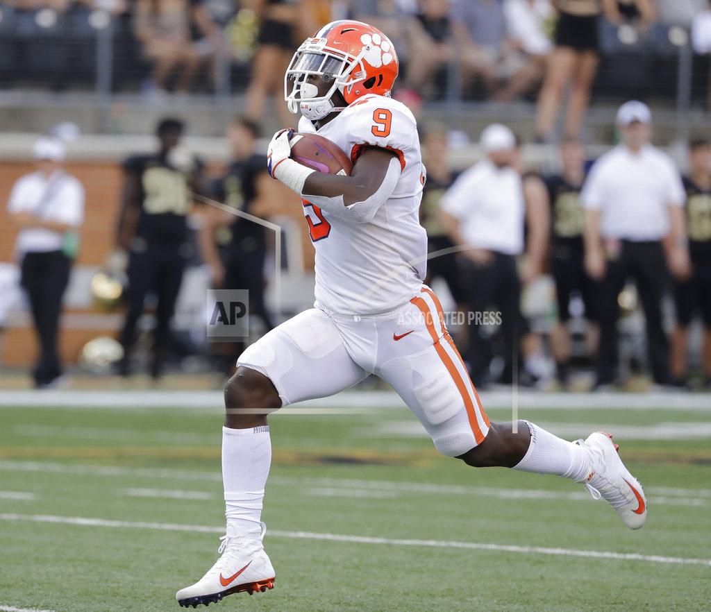 Chuck Burton FILE - In this Oct. 6, 2018, file photo, Clemson's Travis Etienne runs for a touchdown against Wake Forest during an NCAA college football game in Charlotte, N.C. Etienne is the one running back left who might be able to break into the field of Heisman Trophy candidates. His biggest issue is touches. The sophomore is averaging just under 13 carries per game, but 8.6 yards per carry with 15 touchdowns. (AP Photo/Chuck Burton, File)