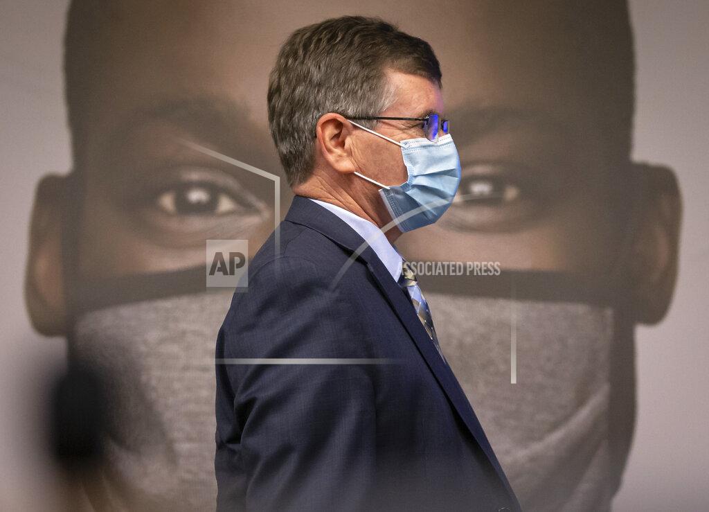 Justin L. Fowler Springfield Mayor Jim Langfelder walks past one of the images used by Illinois Governor JB Pritzker to unveil a new mask awareness campaign called "It Only Works If You Wear It" during a press conference at the IEMA State Emergency Operations Center, Monday, August 3, 2020, in Springfield, Ill. The new $5 million awareness campaign will encourage Illinois residents to wear a face covering every time they're in public. (Justin L. Fowler/The State Journal-Register via AP)