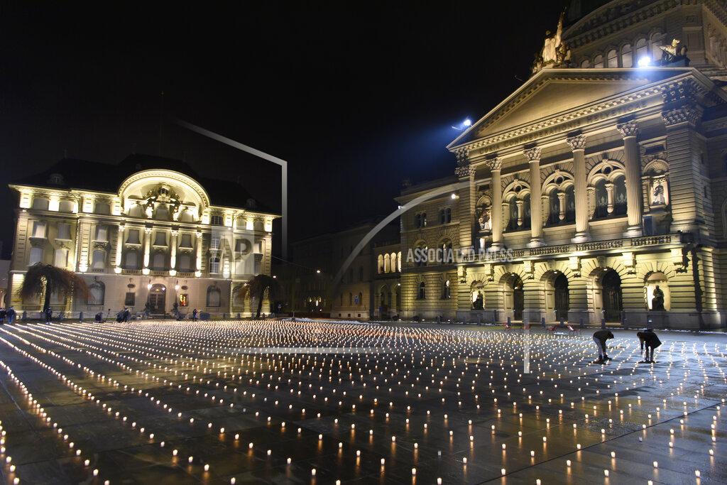 Anthony Anex Activists light about 5,000 candles to commemorate the people who died of the coronavirus in Switzerland, Sunday, Dec. 6, 2020, on the Bundesplatz, front of the Federal Palace, in Bern, Switzerland. (Anthony Anex/Keystone via AP)