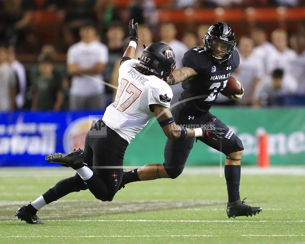 Marco Garcia Hawaii running back Fred Holly III (21) stiff arms UNLV defensive back Evan Austrie (17) during the first quarter of an NCAA college football game, Saturday, Nov. 17, 2018, in Honolulu. (AP Photo/Marco Garcia)