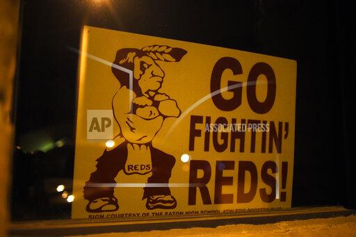 Aaron Ontiveroz FILE--An Eaton Reds sign in a window of a business in this file photograph taken on Monday, September 14, 2015, in Eaton, Colo. Colorado lawmakers are considering a proposal to ban Native American mascots in public schools and colleges. the state Senate Education Committee is scheduled to discuss a measure Thursday, April 1, 2021 that would impose a $25,000 monthly fine on public schools, colleges and universities that continue to use an American Indian-themed mascot after June 1, 2022. (AAron Ontiveroz/The Denver Post via The AP)