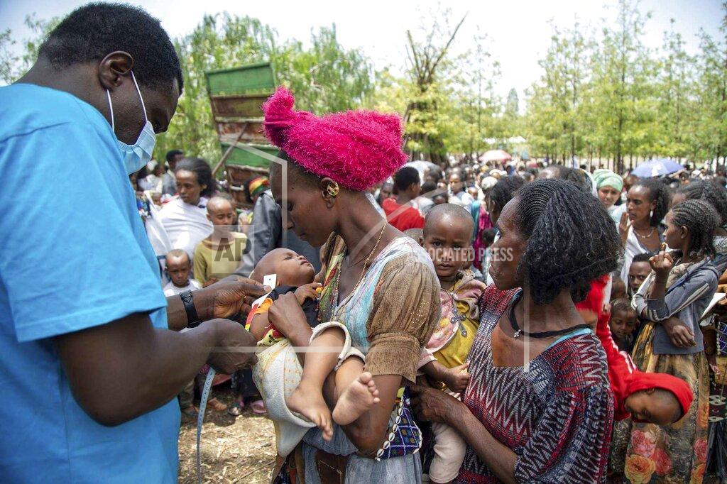 Christine Nesbitt UNICEF Nutrition Specialist Joseph Senesie, left, screens a child for malnutrition in Adikeh, in the Wajirat district of the Tigray region of northern Ethiopia Monday, July 19, 2021. For months, the United Nations has warned of famine in Tigray and now internal documents and witness accounts reveal the first starvation deaths since Ethiopia's government in June imposed what the U.N. calls "a de facto humanitarian aid blockade." (Christine Nesbitt/UNICEF via AP)
