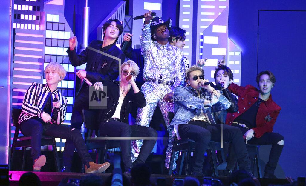 FILE - Lil Nas X, background center, performs "Old Town Road" with members of the Korean pop band BTS at the 62nd annual Grammy Awards in Los Angeles on Jan. 26, 2020. “Dynamite,” the group’s first all-English song, debuted at No. 1 on the U.S. music charts this week, making BTS first Korean pop act to top the chart. (Photo by Matt Sayles/Invision/AP, File)