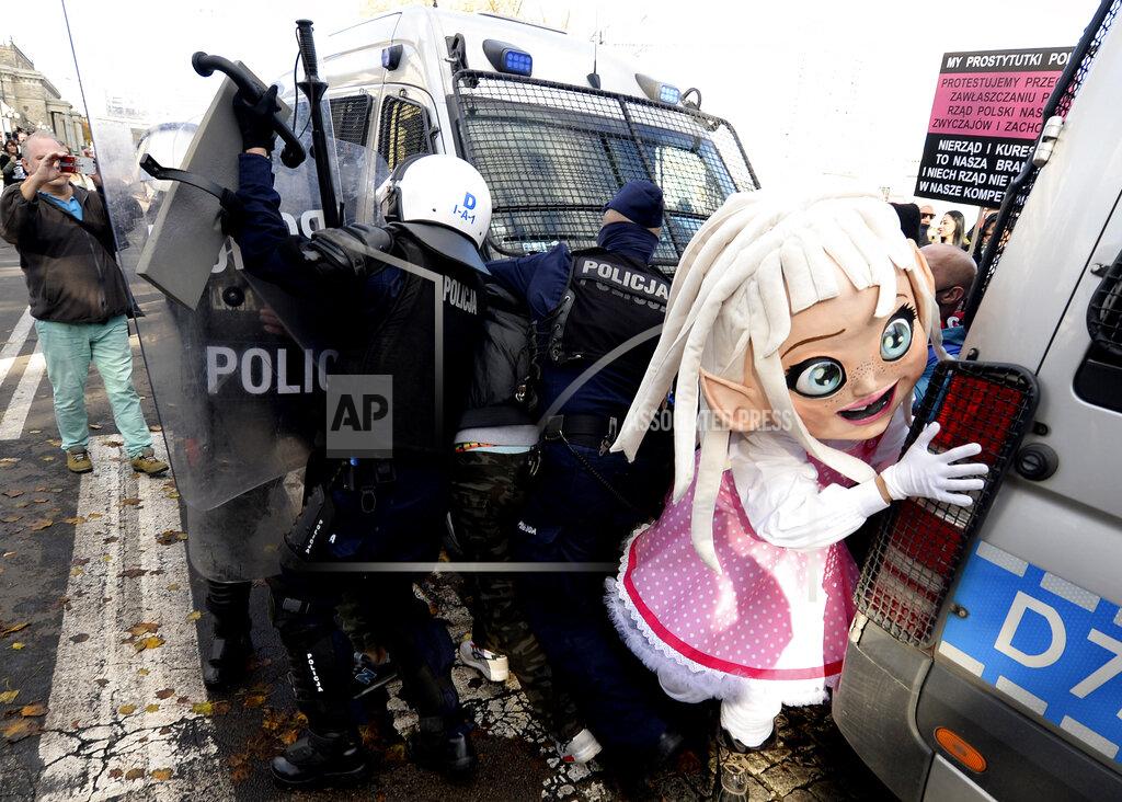 Czarek Sokolowski Polish police in riot gear detain protesters, angry over new restrictions aimed at fighting the coronavirus pandemic, in Warsaw, Poland, Saturday, Oct. 24, 2020. The protesters included entrepreneurs, far-right politicians, football fans and vaccine opponents. The clashes come amid rising social tensions and as new restrictions just short of a full lockdown took effect Saturday. (AP Photo/Czarek Sokolowski)