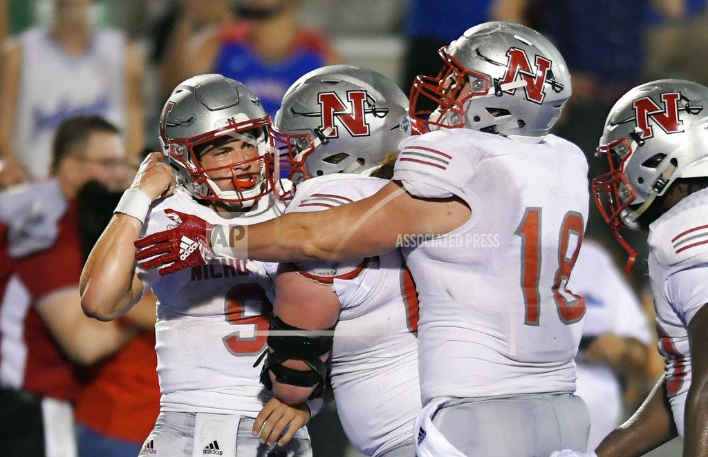 Reed Hoffmann Nicholls State quarterback Chase Fourcade (9) is mobbed by teammates after scoring the winning touchdown in overtime against Kansas during an NCAA college football game in Lawrence, Kan., Saturday, Sept. 1, 2018. (AP Photo/Reed Hoffmann)