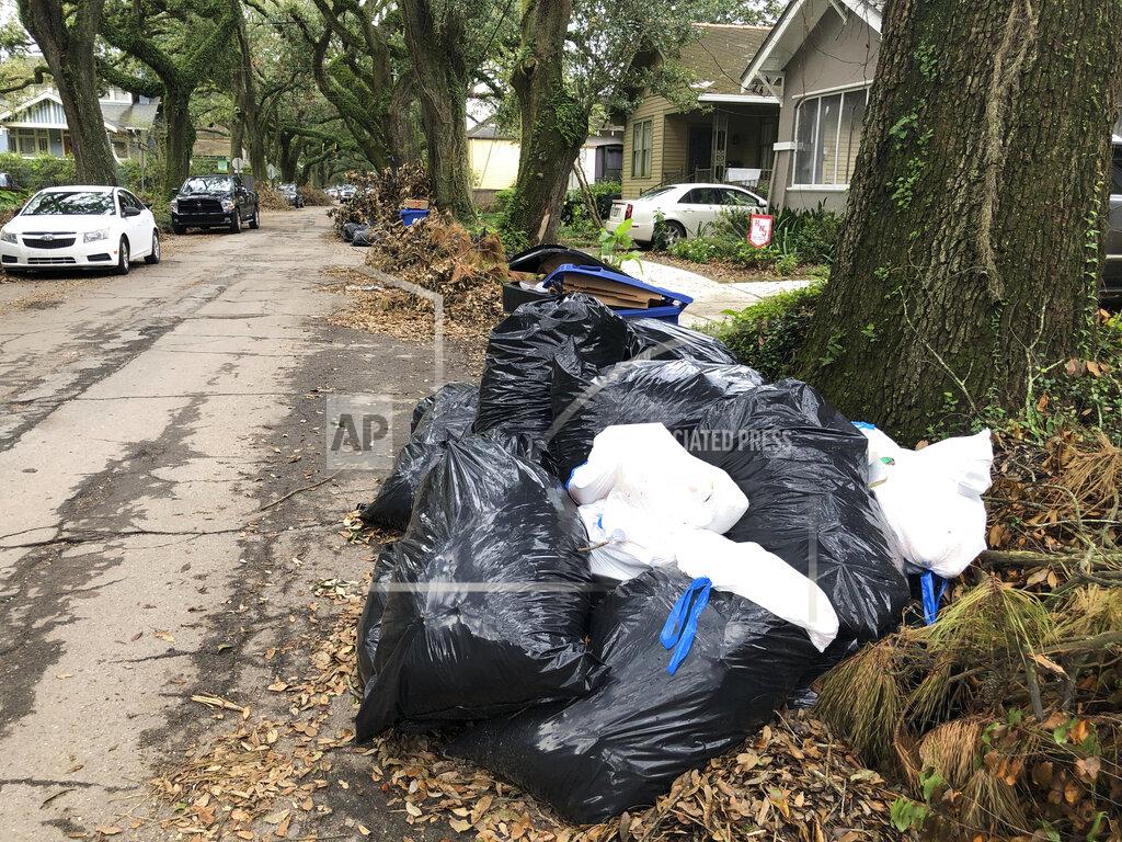Kevin Mcgill Bags and containers of household garbage and piles of storm debris line a New Orleans street, Friday, Sept. 17, 2021. Nearly three weeks after Hurricane Ida struck the city, many residents are growing angry at the lack of garbage pickups in New Orleans— a problem officials say stems from labor shortages that began with the COVID-19 pandemic and were made worse by the storm. (AP Photo/Kevin McGill)