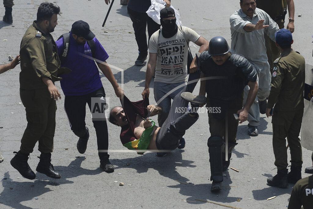 K.M. Chaudary Police officers detain a supporter of Pakistan's key opposition as clashes broke out during a protest march toward Islamabad, in Lahore, Pakistan, Wednesday, May 25, 2022. Pakistani authorities blocked off all major roads into the capital Islamabad on Wednesday, after a defiant former Prime Minister Imran Khan said he would march with demonstrators to the city center for a rally he hopes will bring down the government and force early elections. (AP Photo/K.M. Chaudary)