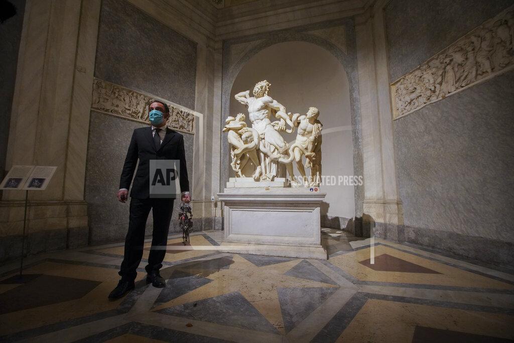 Gianni Crea, the Vatican Museums chief "Clavigero" key-keeper, walks past the Laocoon statue, a masterpiece of the sculptors of Rhodes dated around 40-30 B.C., on his way to open the museum's rooms and sections, at the Vatican, Monday, Feb. 1, 2021. Crea is the “clavigero” of the Vatican Museums, the chief key-keeper whose job begins each morning at 5 a.m., opening the doors and turning on the lights through 7 kilometers of one of the world's greatest collections of art and antiquities. The Associated Press followed Crea on his rounds the first day the museum reopened to the public, joining him in the underground “bunker” where the 2,797 keys to the Vatican treasures are kept in wall safes overnight. (AP Photo/Andrew Medichini)