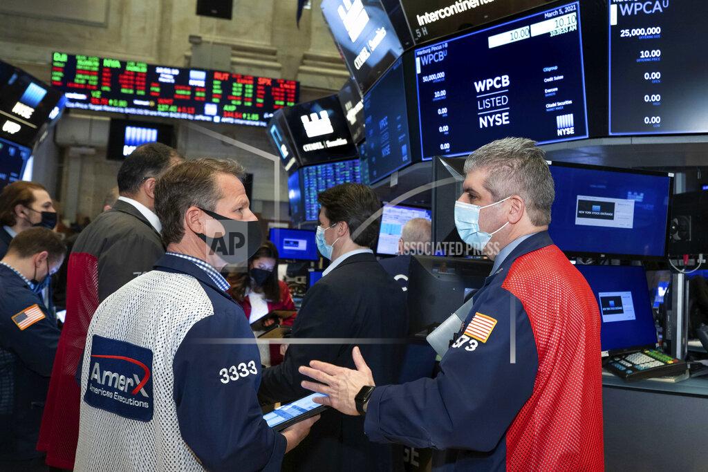 Nicole Pereira In this photo provided by the New York Stock Exchange, traders Robert Charmak and John Panin, foreground left and right, work on the floor, Friday, March 5, 2021, in New York. Stocks are swerving through another rocky ride Friday, as investors struggle to figure out what an encouraging report on the economy and the recent march higher for bond yields should mean for the market. (Nicole Pereira/New York Stock Exchange via AP)