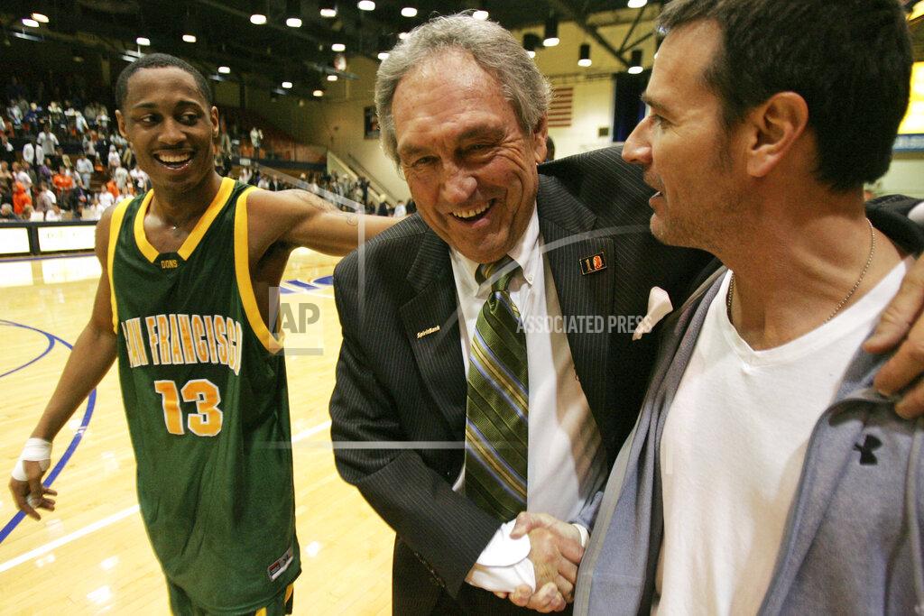 Jeff Lewis FILE - In this Saturday, Feb. 2, 2008, file photo, San Francisco head coach Eddie Sutton shakes the hand of Terry Anzaldo as Myron Strong, left, smiles after San Francisco defeats Pepperdine 88-85 in an NCAA college basketball game to give Sutton his 800th win, in Malibu, Calif. Sutton, the Hall of Fame basketball coach who led three teams to the Final Four and was the first coach to take four schools to the NCAA Tournament, died Saturday, May 23, 2020. He was 84. (AP Photo/Jeff Lewis, File)