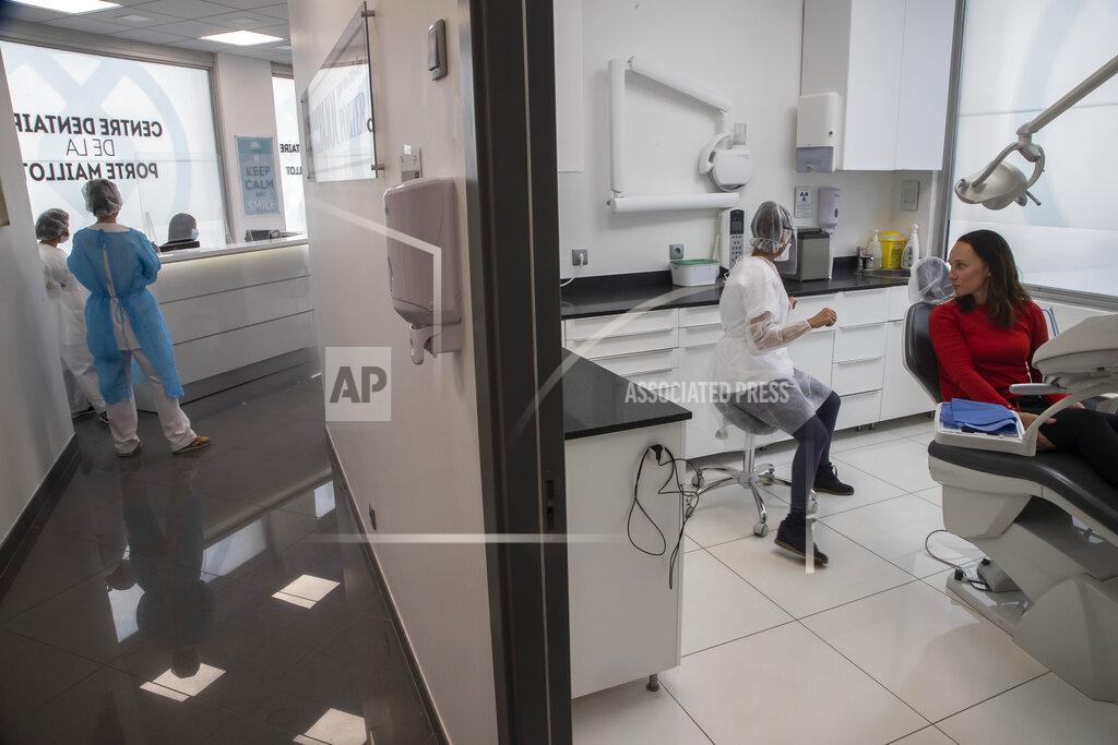 Michel Euler In this Wednesday, May 13, 2020 photo, dentist Sabrine Jendoubi, speaks with patient Veronique Guillot, during a dental appointment, at a dental office in Paris. Those with toothache that suffered through France's two-month lockdown, finally have hope to end the pain. Dental practices are cautiously re-opening and non-emergency dentist appointments are now permitted around the country, as the French government eased confinement restrictions from Monday. (AP Photo/Michel Euler)