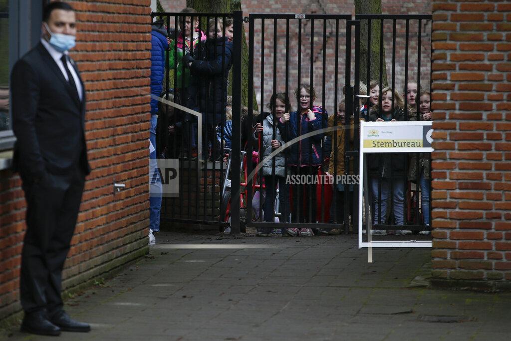 Peter Dejong Children watch Dutch caretaker Prime Minster Mark Rutte answer questions outside a polling station in a school after casting his vote in a general election in The Hague, Wednesday, March 17, 2021. Polling stations have opened opened across the Netherlands from Monday in a general election that has been spread over three days to allow people to vote safely during the coronavirus pandemic. (AP Photo/Peter Dejong)