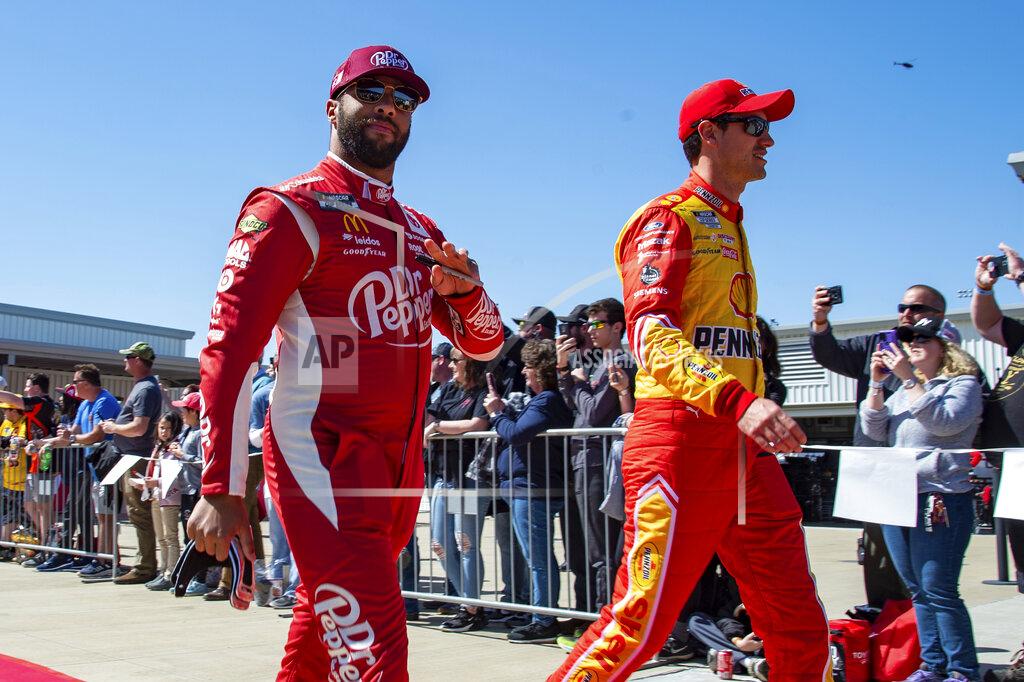 Mike Caudill Bubba Wallace, left, and Joey Logano, right, walk down the red carpet for driver introductions before the start of a NASCAR Cup Series auto race at Richmond Raceway on Sunday, April 3, 2022, in Richmond, Va. (AP Photo/Mike Caudill)