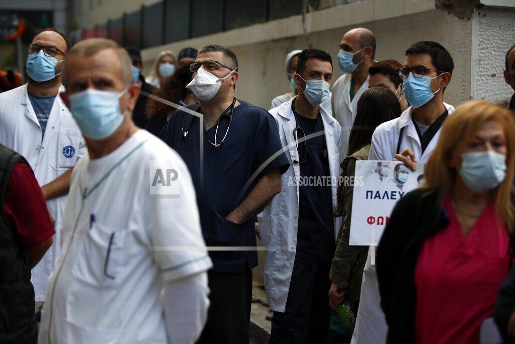 Health workers wearing face masks to protect against the spread of the coronavirus, take part in a protest at Evangelismos hospital in Athens, Thursday, Nov. 12, 2020. State health workers' union staged protests at several hospitals around the country to demand more hiring. Greece has imposed a nationwide nightly curfew as the number of COVID-19 cases in the country continues to surge despite a lockdown. (AP Photo/Thanassis Stavrakis)