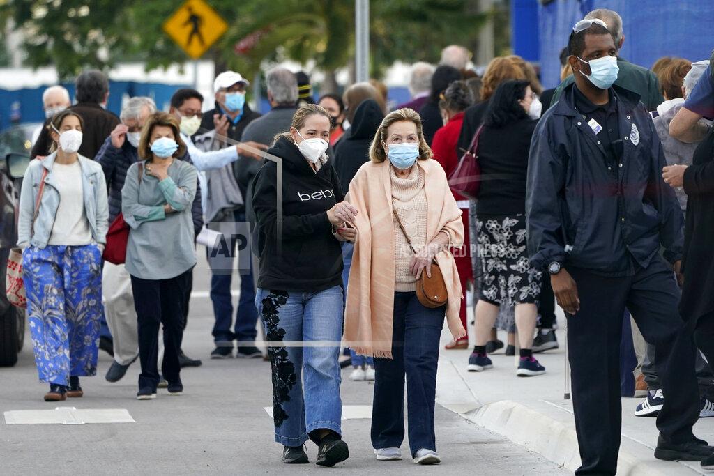 FILE - In this Jan. 6, 2021, file photo, people arrive at Jackson Memorial Hospital to receive the COVID-19 vaccine in Miami. With frustration rising over the slow rollout of the vaccine, state leaders and other politicians are turning up the pressure, improvising and seeking to bend the rules to get shots in arms more quickly. (AP Photo/Lynne Sladky, File)