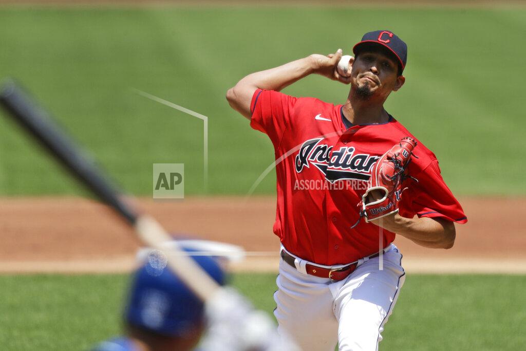 Tony Dejak Cleveland Indians starting pitcher Carlos Carrasco, top, delivers to Kansas City Royals' Whit Merrifield in the first inning in a baseball game Sunday, July 26, 2020, in Cleveland. (AP Photo/Tony Dejak)