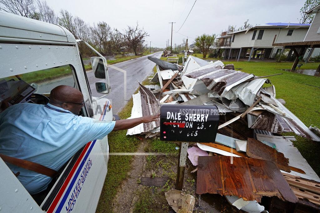 Gerald Herbert Derrick Campbell, postmaster for Montegut, La., delivers mail amidst destruction from Hurricane Ida, in Pointe-aux-Chenes, La., Tuesday, Sept. 14, 2021. (AP Photo/Gerald Herbert)