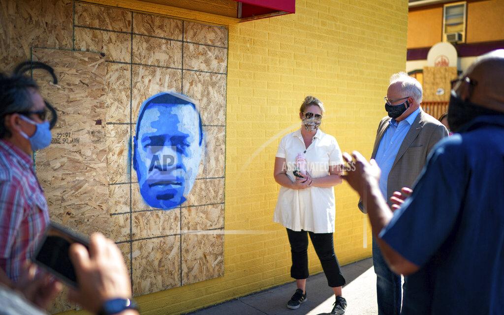 Glen Stubbe CORRECTS SPELLING TO SEITU, INSTEAD OF SEITO - Minnesota Gov. Tim Walz, second from right, listens as artist Seitu Jones, right, talks about his stencil of George Floyd that is free for download by anyone, Monday, June 8, 2020, in St. Paul, Minn. Walz took a walking tour of some of the artworks commissioned by Springboard for the Arts along University Avenue. At left is Springboard Executive Director Laura Zabel. (Glen Stubbe/Star Tribune via AP, Pool)