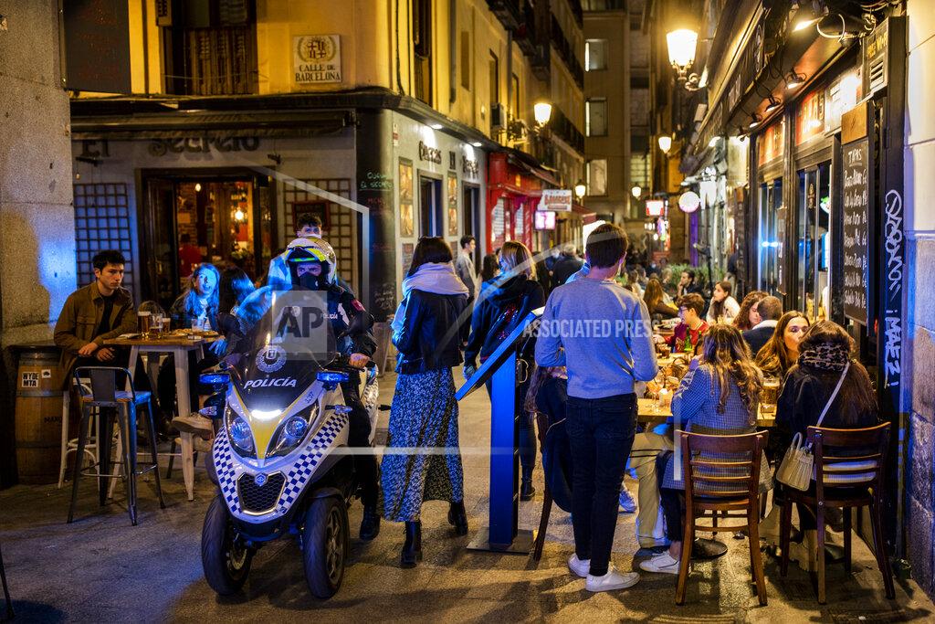 Bernat Armangue Policeman patrols in downtown Madrid, Spain, Friday, March 26, 2021. With its policy of open bars and restaurants — indoors and outdoors — and by keeping museums and theaters running even when outbreaks have strained hospitals, Madrid has built a reputation as an oasis of fun in Europe’s desert of restrictions. Other Spanish regions have a stricter approach to entertainment. Even sunny coastal resorts offer a limited range of options for the few visitors that started to arrive, coinciding with Easter week, amid a set of contradictory European travel rules. (AP Photo/Bernat Armangue)