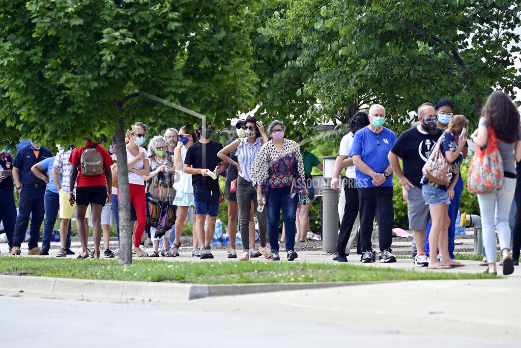 FILE-In this Tuesday, June 23, 2020 file photo, voters waited patiently in line to cast their ballots in the Kentucky primary at Kroger Field in Lexington, Ky. Voter turnout was much heavier than expected leading to wait time of 90 minutes or longer. There was only one polling place open on election day this week in Louisville, Kentucky, and voting went relatively smoothly compared to other recent primaries amid the global pandemic. Does that mean other cities should consider the same in November?(AP Photo/Timothy D. Easley)