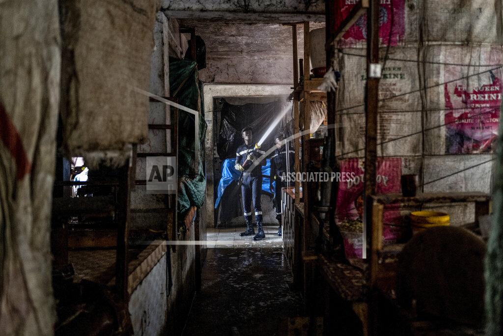 Sylvain Cherkaoui Firefighters use a hose to spray water to clean the Colobane market, which has been closed to the public for one week in an attempt to halt the spread of the new coronavirus, in the capital Dakar, Senegal Wednesday, March 25, 2020. The new coronavirus causes mild or moderate symptoms for most people, but for some, especially older adults and people with existing health problems, it can cause more severe illness or death. (AP Photo/Sylvain Cherkaoui)