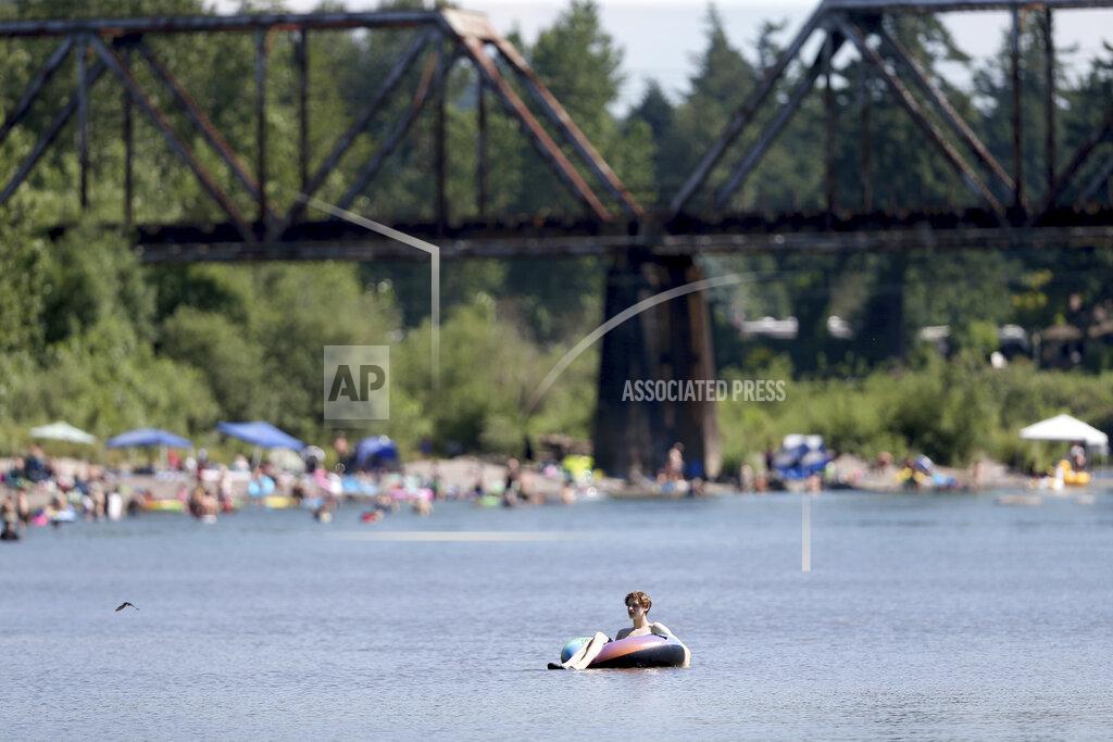 Dave Killen People gather at the Sandy River Delta, in Ore., to cool off during the start of what should be a record-setting heat wave on June 25, 2021. The Pacific Northwest sweltered Friday as a historic heat wave hit Washington and Oregon, with temperatures in many areas expected to top out 25 to 30 degrees above normal in the coming days. (Dave Killen/The Oregonian via AP)