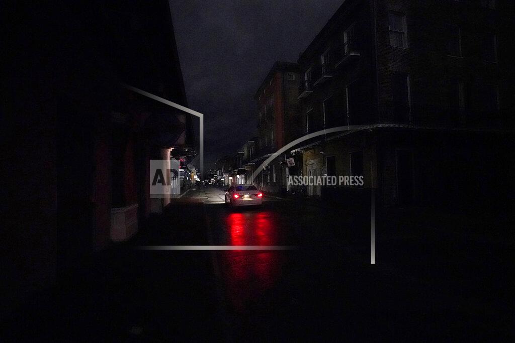 Gerald Herbert A passing car's headlights illuminate a darkened Bourbon Street in the French Quarter of New Orleans, Wednesday, Oct. 28, 2020. Hurricane Zeta passed through Wednesday leaving much of the city and metro area without power. (AP Photo/Gerald Herbert)