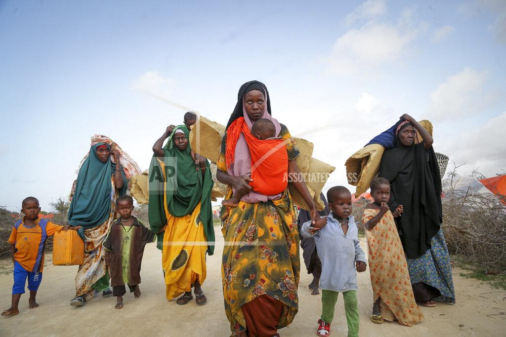 Farah Abdi Warsameh Somalis who fled drought-stricken areas carry their belongings as they arrive at a makeshift camp for the displaced on the outskirts of Mogadishu, Somalia Thursday, June 30, 2022. The war in Ukraine has abruptly drawn millions of dollars away from longer-running humanitarian crises and Somalia is perhaps the most vulnerable as thousands die of hunger amid the driest drought in decades. (AP Photo/Farah Abdi Warsameh)