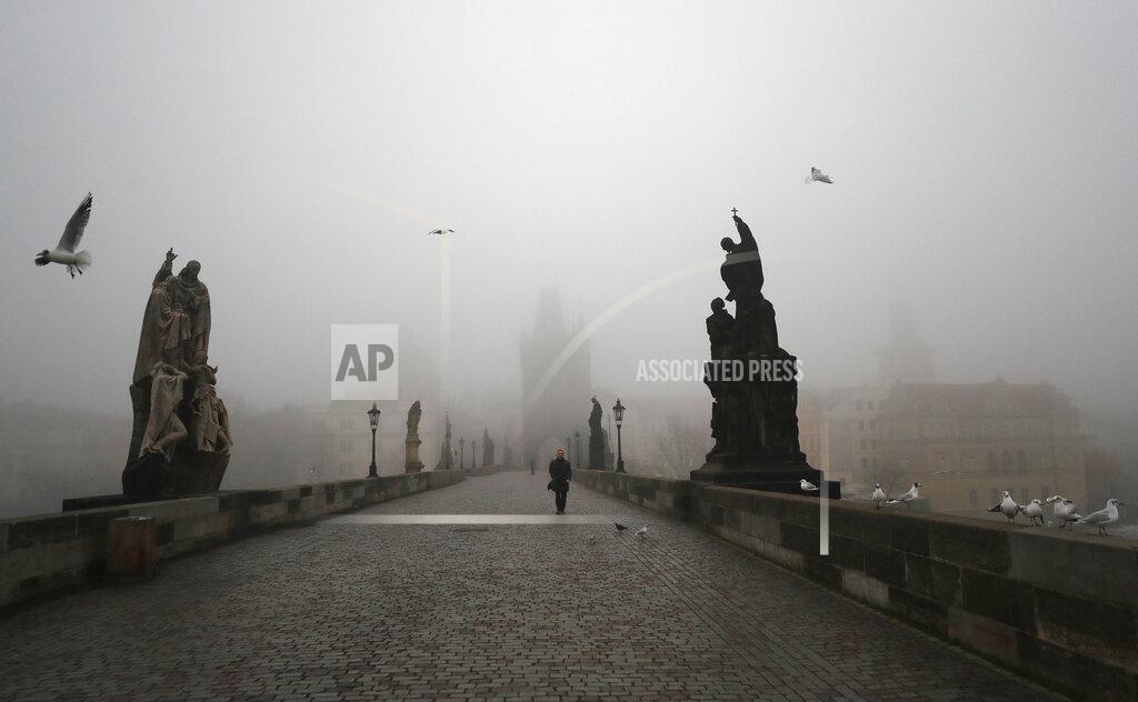 Petr David Josek A man walks across the medieval Charles Bridge in Prague, Czech Republic, Wednesday, Feb. 24, 2021. The Czech government has decided to further tighten restrictive measures amid a surge of a highly contagious coronavirus variant in one of the hardest-hit European Union's nations. At the same time, the worsening situation has forced the Cabinet to abandon for now its plans to reopen all stores. (AP Photo/Petr David Josek)