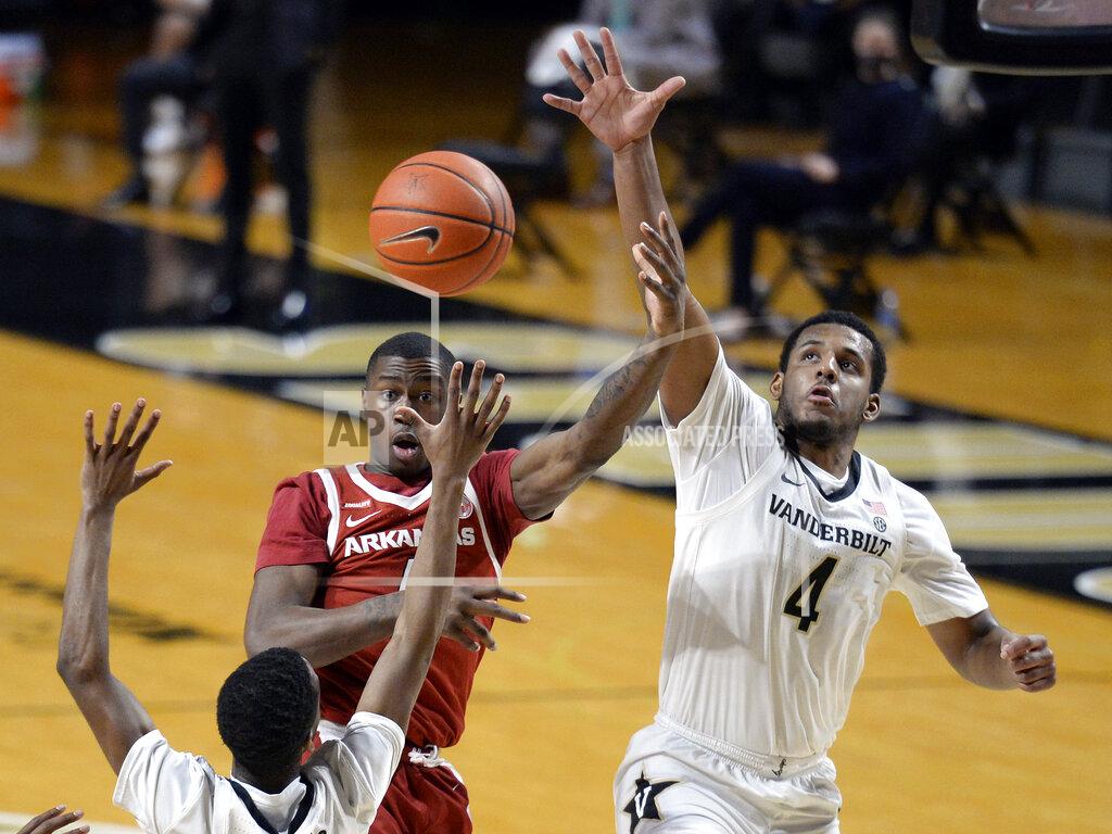 Mark Zaleski Arkansas guard Davonte Davis (4) passes the ball as he is defended by Vanderbilt guard's Trey Thomas, left, and Jordan Wright (4) during the second half of an NCAA college basketball game against Vanderbilt Saturday, Jan. 23, 2021, in Nashville, Tenn. Arkansas won 92-71. (AP Photo/Mark Zaleski)