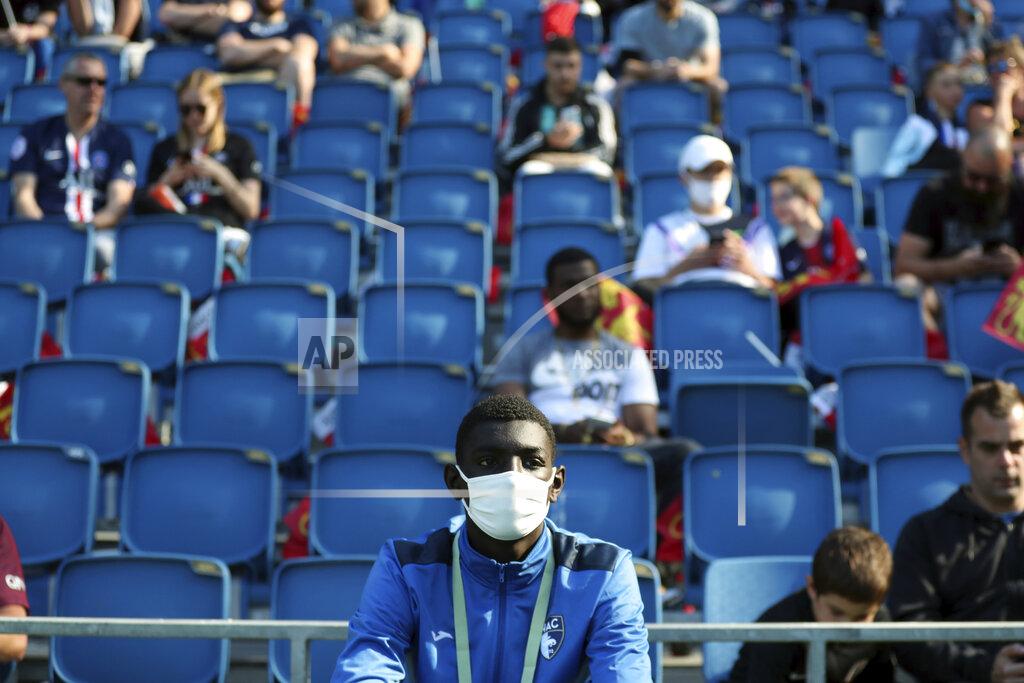 A ball carrier wears a face mask prior to the friendly soccer match between Paris Saint Germain and Le Havre, in Le Havre, western France, Sunday, July 12, 2020. For the first time since the coronavirus shut down sports and chased away spectators, Neymar, Kylian Mbappe and other soccer stars are going to play again in front of fans. (AP Photo/Thibault Camus)