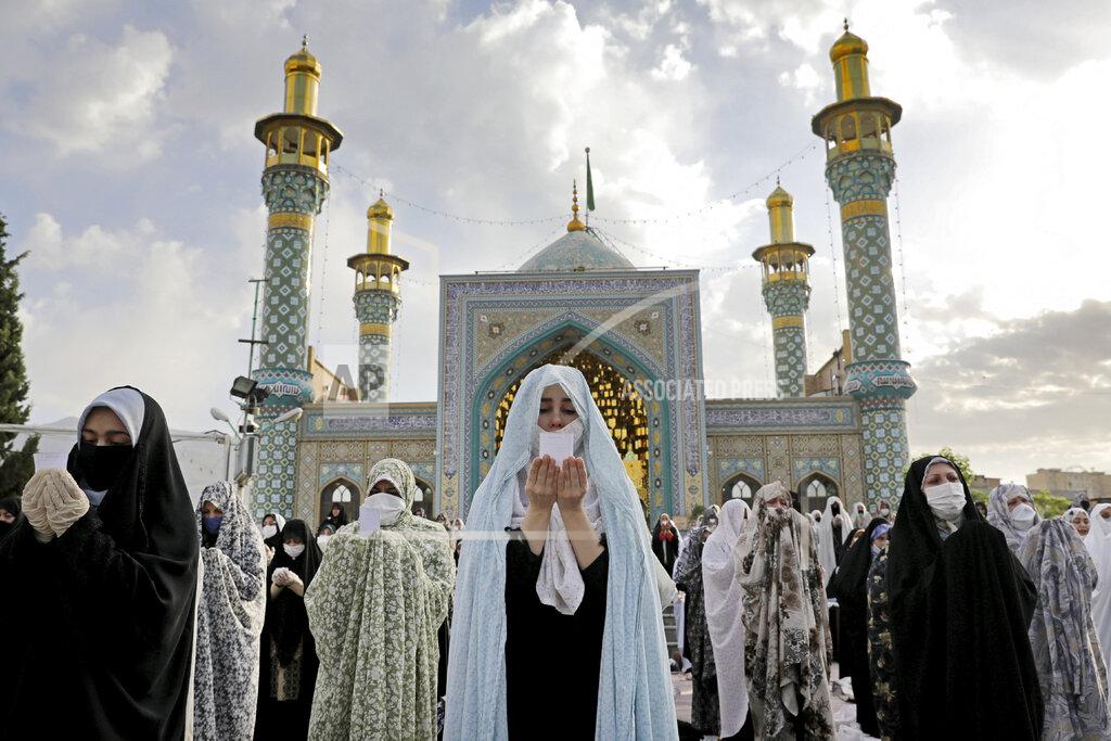 Ebrahim Noroozi Worshippers wearing protective face masks offer Eid al-Fitr prayers outside a shrine to help prevent the spread of the coronavirus, in Tehran, Iran, Sunday, May 24, 2020. Muslims worldwide celebrated one of their biggest holidays under the long shadow of the coronavirus, with millions confined to their homes and others gripped by economic concerns during what is usually a festive time of shopping and celebration. (AP Photo/Ebrahim Noroozi)