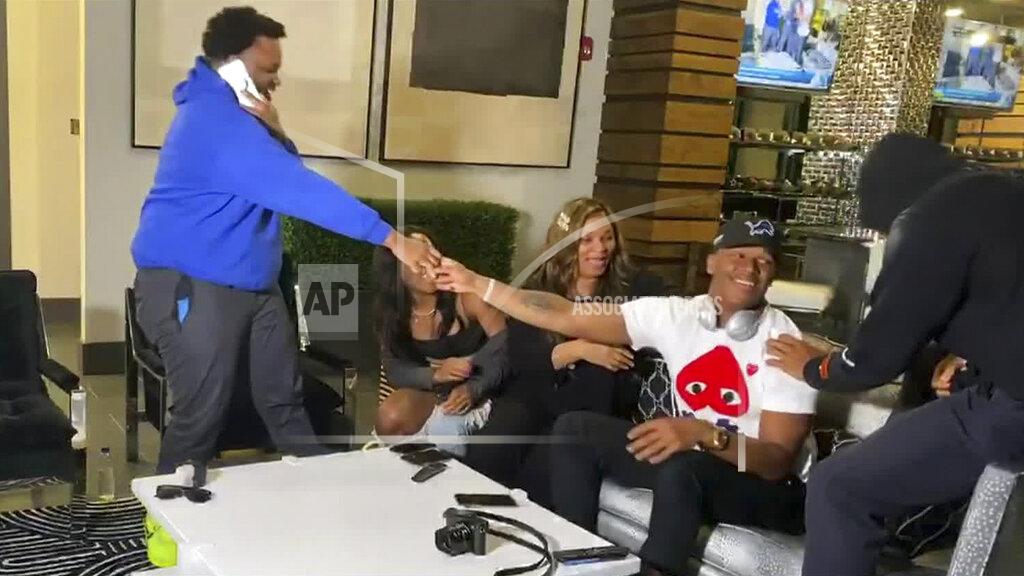 Uncredited In this still image from video provided by the NFL, Julian Okwara, seated wearing cap, is congratulated after being selected by the Detroit Lions during the third round of the NFL football draft, Friday, April 24, 2020. (NFL via AP)