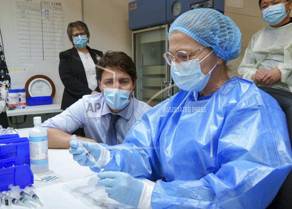 Paul Chiasson Canada's Prime Minister Justin Trudeau watches as a COVID-19 vaccine is prepared while he tours a vaccination clinic in Montreal, on Monday, March 15, 2021. (Paul Chiasson/The Canadian Press via AP)