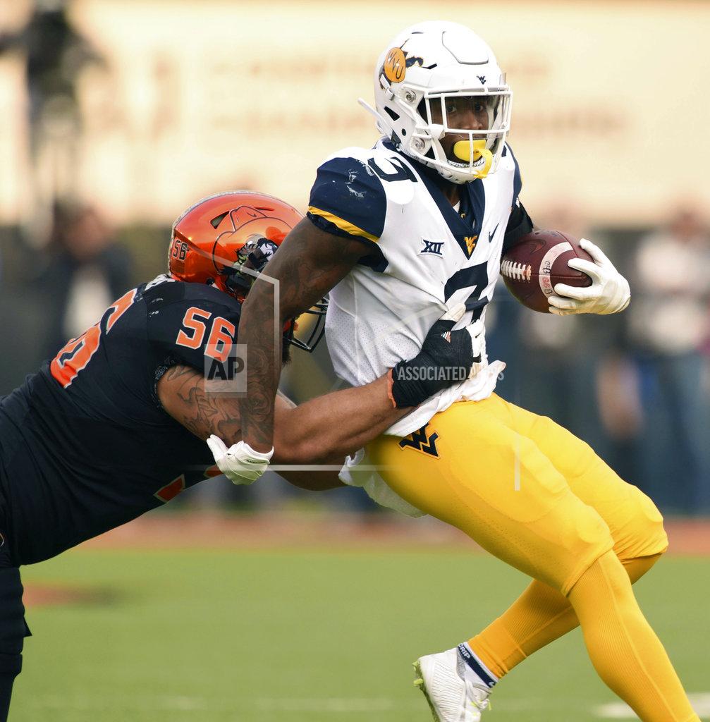 Brody Schmidt West Virginia safety Toyous Avery Jr. (3) is tackled by Oklahoma State offensive lineman Larry Williams (56) following a West Virginia interception during the first half of an NCAA college football game in Stillwater, Okla., Saturday, Nov. 17, 2018. (AP Photo/Brody Schmidt)