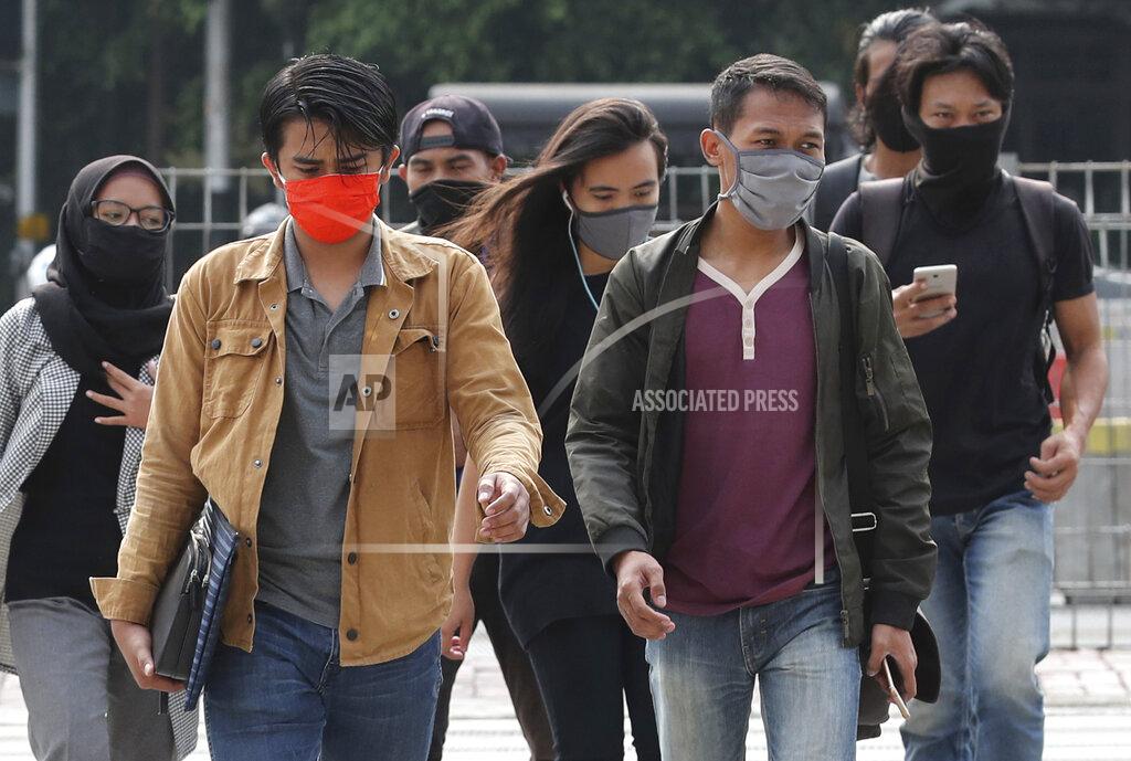 Tatan Syuflana People, wearing a face mask as a precaution against the new coronavirus outbreak, walk on a pedestrian crossing at the main business district in Jakarta, Indonesia, Monday, Sept. 14, 2020. Indonesia's capital on Monday begins to reimpose large-scale social restrictions to control a rapid expansion in the virus cases. (AP Photo/Tatan Syuflana)