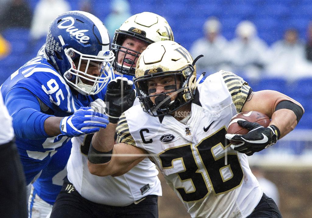 Ben Mckeown Wake Forest's Cade Carney (36) carries the ball past the reach of Duke's Trevon McSwain (95) during the first half of an NCAA college football game in Durham, N.C., Saturday, Nov. 24, 2018. (AP Photo/Ben McKeown)