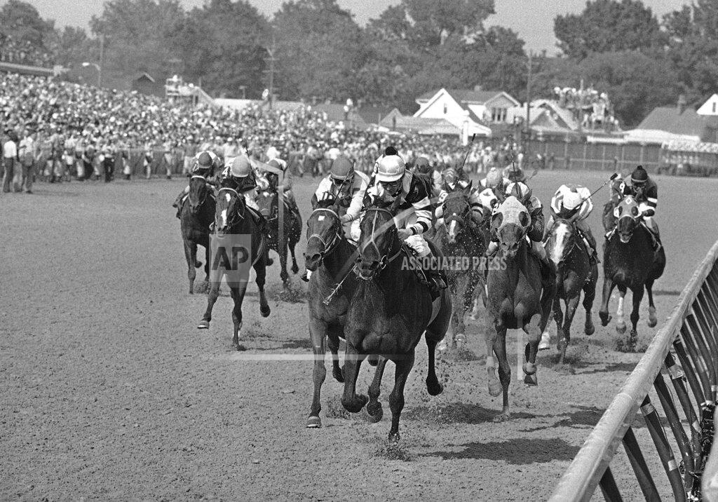 Anonymous FILE - In this May 7, 1977, file photo, Seattle Slew, with Jean Cruguet up, crosses finish line to win the Kentucky Derby horse race at Churchill Downs in Louisville, Ky. Run Dusty Run, left of Seattle Slew, finished second, and Sanhedrin, just to right of Seattle Slew, finished third. Secretariat is the early 7-2 favorite for this weekend’s virtual Kentucky Derby, an animated race pitting all 13 Triple Crown winners on the day the Derby would have been held before the coronavirus pandemic postponed it. Citation, who won the 1948 Triple Crown, was made the 4-1 second choice. Seattle Slew and Affirmed, the 1977 and '78 Triple Crown winners, were each listed at 5-1 odds. (AP Photo/File)