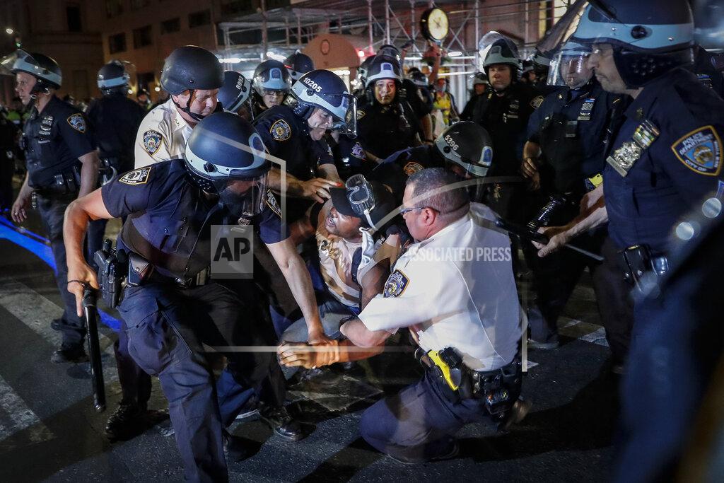 A protester is arrested on Fifth Avenue by NYPD officers during a march, Thursday, June 4, 2020, in the Manhattan borough of New York. Protests continued following the death of George Floyd, who died after being restrained by Minneapolis police officers on May 25. (AP Photo/John Minchillo)