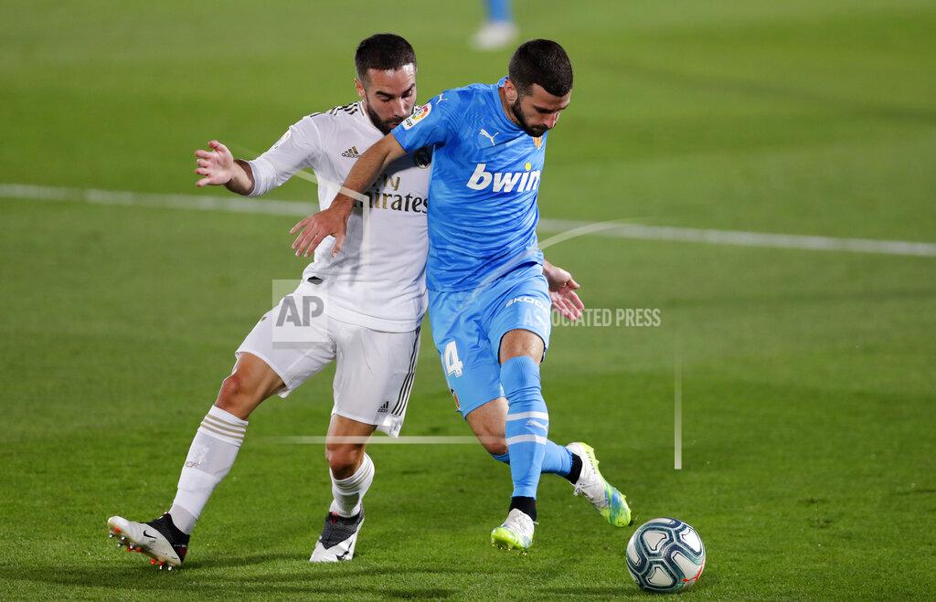 Manu Fernandez Real Madrid's Dani Carvajal, left, challenges for the ball with Valencia's Jose Luis Gaya during the Spanish La Liga soccer match between Real Madrid and Valencia at Alfredo di Stefano stadium in Madrid, Spain, Thursday, June 18, 2020. (AP Photo/Manu Fernandez)